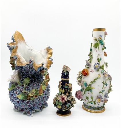 Lotto composto da tre diversi vasi in porcellana policroma con applicazioni a r