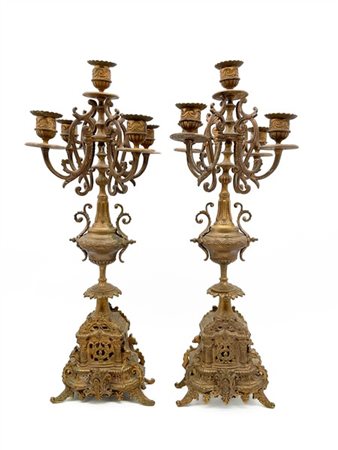 Coppia di candelabri a cinque fiamme in metallo dorato con decoro a volute e so
