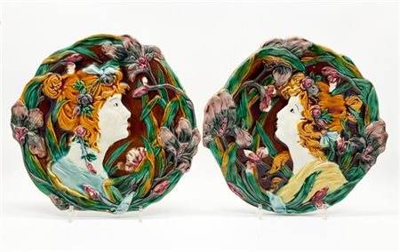 Coppia di placche Liberty in ceramica policroma con decorazione a rilievo a pro