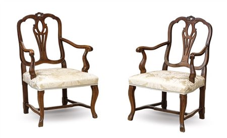 Coppia di antiche poltrone in noce intagliato di forma mossa, gambe raccordate