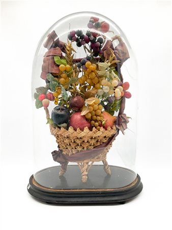 Composizione con frutti su cesto in materiali vari entro campana in vetro su ba