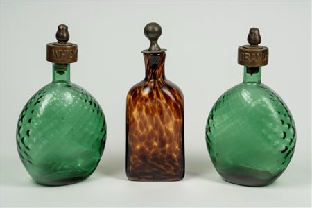 Tre decanter in vetro con tappi in metallo