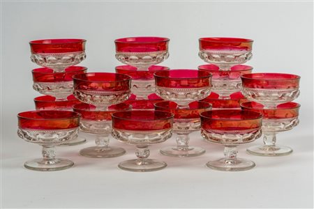 Diciotto coppe da macedonia in vetro trasparente con bordo rosso rubino, fascia e stelo baccellati su piede circolare