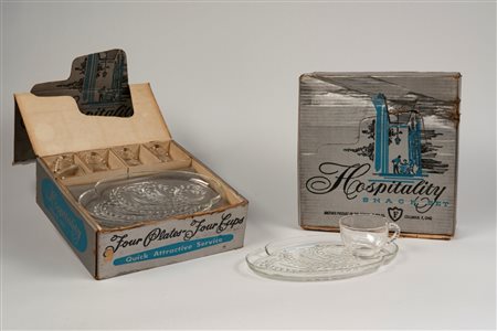 Due Snack set composti da quattro tazze e quattro vassoietti di forma mossa con decoro a rami fogliati in vetro trasparente, American production, Ohio
