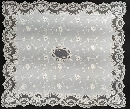 Tovaglia in lino e pizzo bianco a profilo mosso con ricami a motivi floreali. Inizio secolo XX