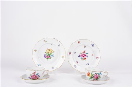 Lotto composto da due tazze da te con piattino e piatto da dolce in porcellana decorata a motivi floreali. Herend, Ungary