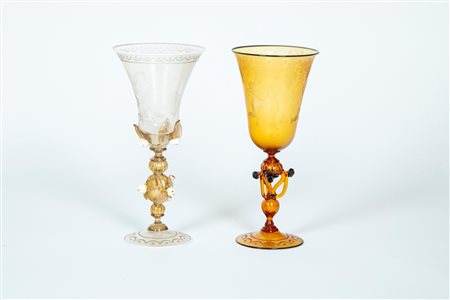Due calici da parata in vetro soffiato di Murano uno trasparente e l'altro color ambra incisi a bulino uno con leone di san Marco e l'altro a putti bacchici, XX secolo