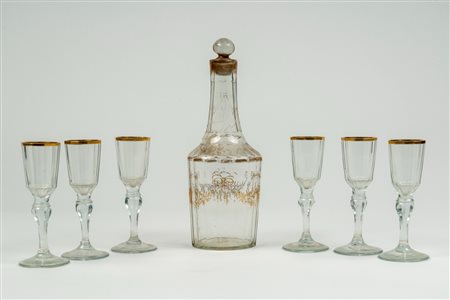 Set da liquore composto da una bottiglia e sei calici in vetro con decori e bordo in oro. Fine secolo XIX-inizo XX