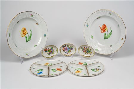 Lotto in porcellana di Herend composto da due piccole antipastiere tripartite, due piatti fondi e tre piccole ciotole ovali in porcellana policroma con decoro a fiori