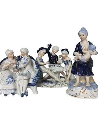 Lotto di tre gruppi scultorei in porcellana policroma bianco e blu.