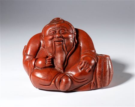  
Figura di saggio scolpita e incisa in pietra saponaria rosso corallo. Cina, inizio XX secolo 
 cm 10 x 11 x 8