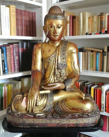  
Figura di Buddha nella Posizione del Loto. Legno laccato e dorato con applicazioni in stucco e paste vitree posto su base in legno e lacca nera. Birmania, Mandalay, XIX secolo 
 Scultura cm 96 x 76 x 50 ca - Base cm 70 x 82 x 55 ca.