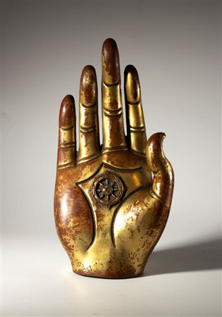  
Mano di Buddha in rame parzialmente dorato. Al centro del palmo la ruota del dharma. Birmania, XX secolo 
 Complessivamente cm 29 x 14.5 x 8 ca.