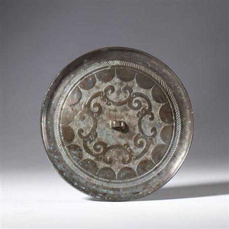  
Specchio in rame argentato utilizzato nel taoismo come strumento rituale.  Cina, dinastia Qing (1644-1912), XIX secolo 
 Diametro mm 98.5