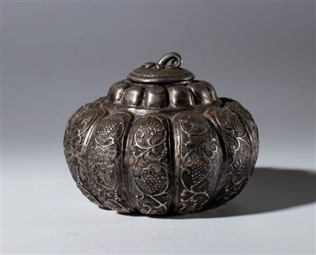  
Contenitore con coperchio a forma di zucca con incisioni a tralci vegetali e animali. Metallo argentato. Cina,  periodo Repubblica (1912-1944)inizio XX secolo 
 mm 77 x 10