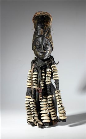  
Feticcio in legno, stoffa, e conchiglie cauri, raffigurante l'Eshu Elegba, divinità del culto Yoruba. Africa, Nigeria, 1900 ca. 
 Altezza cm 35