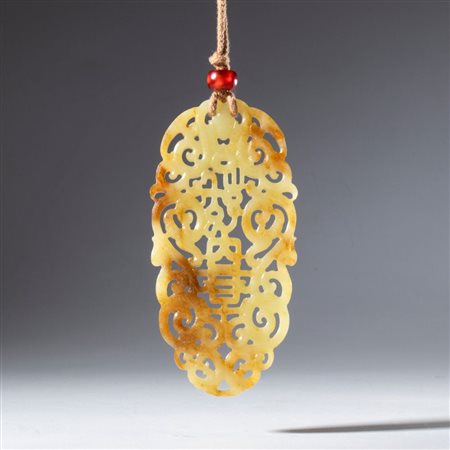  
Pendente ornamentale in giada russet Hotan traforata e incisa. Sospesa con un cordone tenuto alla base da una perla in corniola. Cina, dinastia Qing (1644-1912), XVIII secolo 
 Complessivo mm 89.8 x 44.5 x 5.8
