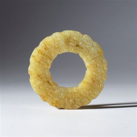 
Disco BI in giada Hotan con motivo inciso e a rilievo raffigurante nuvole. Cina, dinastia Qing (1644-1912), fine XVIII-XIX secolo 
 Diametro esterno mm 60 Spessore mm 6