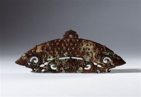  
Mezzo disco ornamentale in giada scura Hotan incisa e traforata. Decorato con motivi a spirale e faccia di tigre. Foro per sospensione. Cina, dinastia Qing (1644-1912), XVII secolo 
 Complessivo mm 118.5 x 44.7 x 5.7