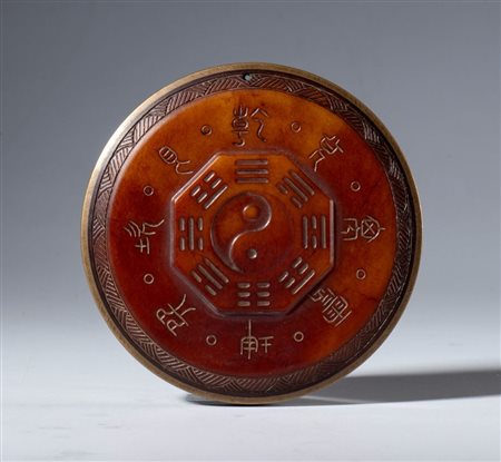  
Targa in giada rossa Hotan con iscrizioni protettive taoiste. Al centro il simbolo del Tao circondato dagli otto trigrammi I Ching. Cina, XX secolo 
 Diametro mm 75