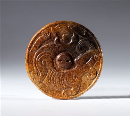 
Disco in giada Hotan con drago in rilievo e foro per sospensione. Cina, dinastia Qing, (1644-1912), fine XVII secolo 
 Diametro mm 56.5