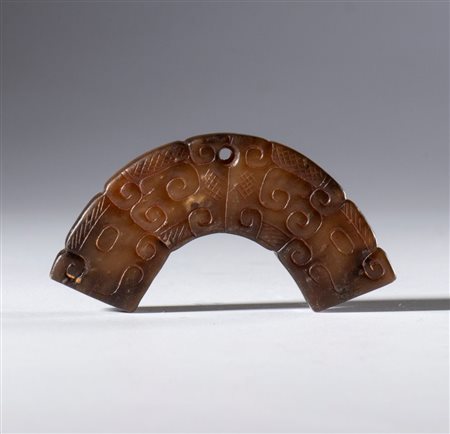  
Mezzo disco ornamentale in giada Hotan incisa con motivi a nuvole e foro per sospensione. Cina, dinastia Qing (1644-1911), XIX secolo 
 Complessivo mm 56.5 Spessore mm 7.2