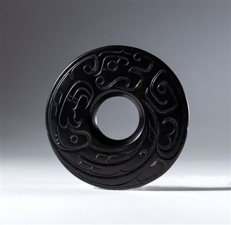  
Disco BI in giada nera Hotan con decoro inciso raffigurante un drago schematizzato, Cina, dinastia Qing (1644-1912), XIX secolo 
 Diametro esterno mm 75 Spessore mm 4.7