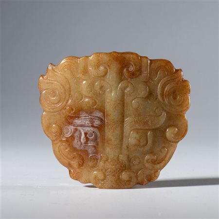  
Pendente ornamentale in giada Hotan scolpita e incisa a forma di testa di drago schematizzato. Cina,  dinastia Qing (1644-1912), XIX secolo 
 mm 52.3 x 58.5 x 10.5