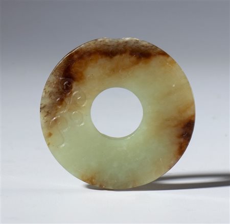  
Bel disco Bi in giada trasparente con screziature cromatiche scure e con incisioni a piccole spirali. Cina, dinastia Qing (1644-1912), fine XIX secolo 
 Diametro esterno mm 48.3
