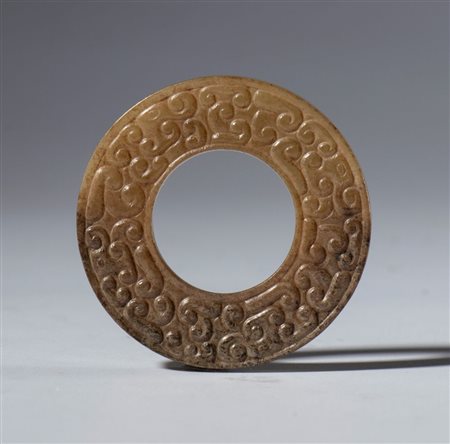  
Disco BI in giada nefrite con incisioni a motivo di nuvole. Cina, Inizio XX secolo 
 Diametro esterno mm 39.4