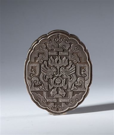  
Elemento decorativo in argento sbalzato e inciso con foro passante per sospensione. Riccamente decorato con draghi e nuvole schematizzati. Cina, XX secolo 
 mm 68 x 55 x 12