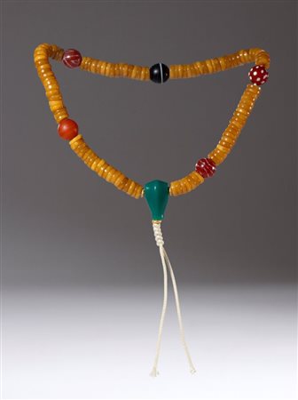  
Mala rituale composta da 108 grani discoidali in osso intervallati da cinque perle in agata, corniole e vetro con grano centrale in giada verde. Cina, dinastia Qing (1644-1911), XIX secolo 
 Lunghezza complessiva cm 19 ca.
