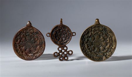  
Lotto di tre amuleti Jiu Gong Ba Gua, in lega di rame. Tibet, XIX secolo 
 Diametro mm 47 / diametro mm 42.7 / mm 54 x 37.7
