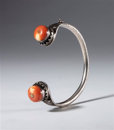  
Bracciale ornamentale in argento con due antiche perle in corallo. Tibet, XIX secolo 
 Diametro interno massimo mm 58