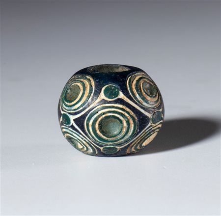  
Antica perla in vetro opaco bianco blu scuro con motivi a spirale. Cina, Periodo degli Stati Combattenti (475-221 a.C) 
 Diametro mm  23 