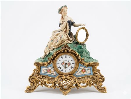 Orologio da camino figurale in bronzo dorato e porcellana con movimento Kienzle