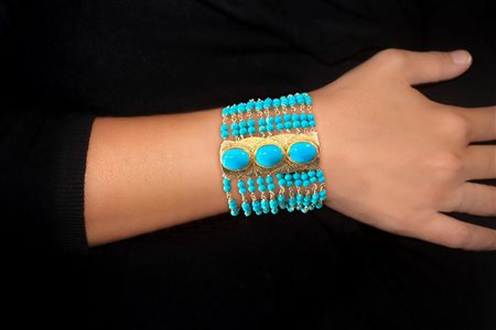 Bracciale in argento 925 a fascia con 11  fili con grani di turchesi intervallati da tre bande con medaglioni in turchese e chiusura di sicurezza
