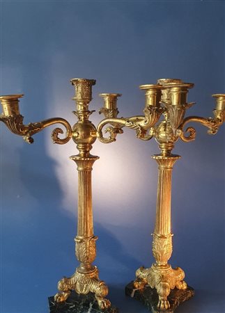  
Coppia candelieri impero. Bronzo dorato. Prima metà XIX secolo.  Lieve sbeccatura su una base in marmo.  
 Ciascuno cm 47 x 31 x 31