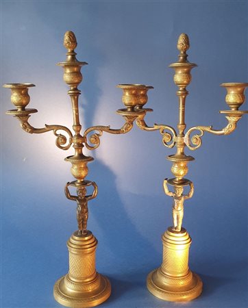  
Coppia di candelieri con putti. Bronzo dorato e patinato nero.  Primo XIX secolo. 
 cm 44,5 x 22 x 11 