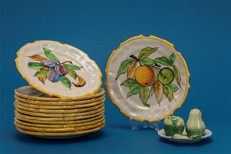 Dodici piattini in ceramica smaltata policroma decorati a frutti accompagnato da saliera e pepiera in forma di frutti 