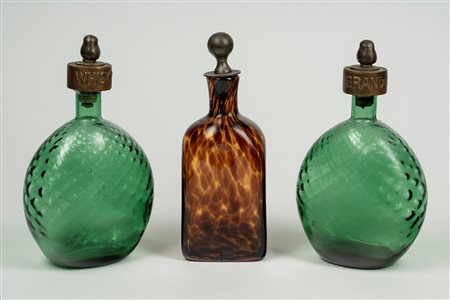 Tre decanter in vetro con tappi in metallo