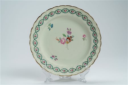 Piatto a profilo mosso e dorato in porcellana con decoro policromo alla rosa e ghirlanda intrecciata. Derby, fine secolo XVIII