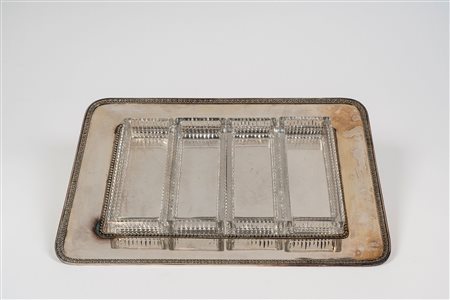 Vassoio porta vivande in metallo argentato di forma rettangolare ad angoli stondati con bordo decorato a palmette, contenitori in cristallo molato.