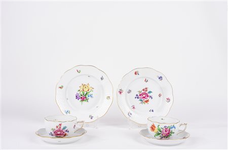 Lotto composto da due tazze da te con piattino e piatto da dolce in porcellana decorata a motivi floreali. Herend, Ungary