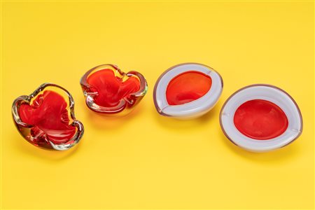 Quattro posaceneri: due a forma di trifoglio in vetro incolore e rosso e due a forma ovale in vetro policromo rosso e azzurro