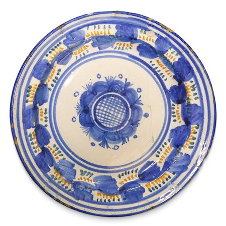 Piatto in ceramica Talavera/Manises con decori nei toni dell'azzurro giallo e verde sul bordo e grande fiore blu al centro, 19th secolo