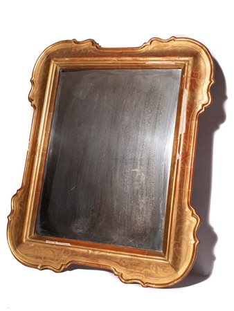  
Specchiera intagliata in legno sagomato e dorato Italia, XIX secolo
 Altezza x larghezza: 86 x 72 cm. Altezza x larghezza luce: 46,5 x 63 cm.