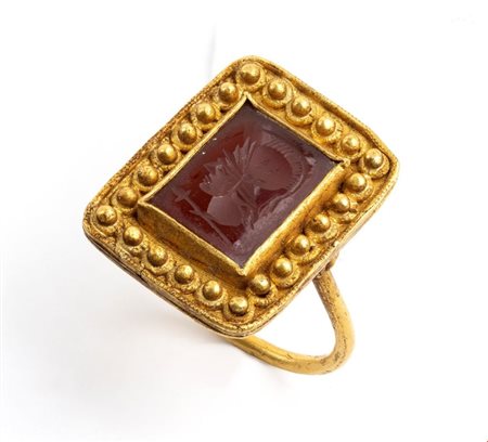 Anello in stile archeologico in oro e corniola incisa di forma rettangolare...