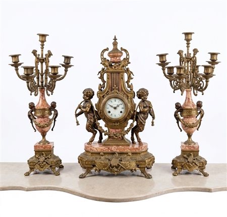 Trittico da camino in stile Luigi XV composto da un orologio centrale e una coppia di candelabri a cinque luci coordinati in bronzo