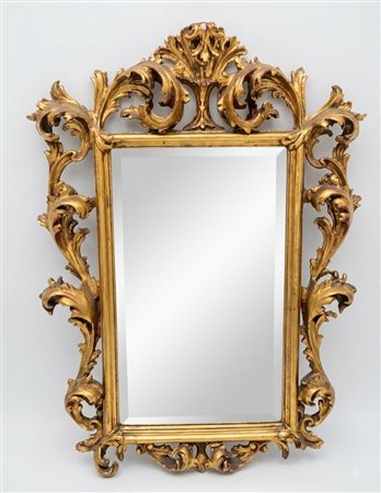 Elegante specchio sagomato con cornice e volute e rocailles in patina dorata cm 70x60